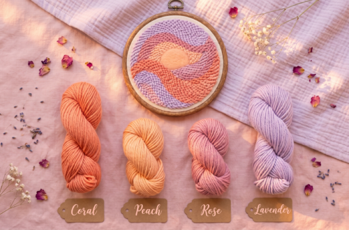 Punch needle template and color palette inspiration for nursery decor. A completed abstract sunset hoop art is displayed with matching labeled yarn skeins (Coral, Peach, Rose, Lavender) on a soft pink background