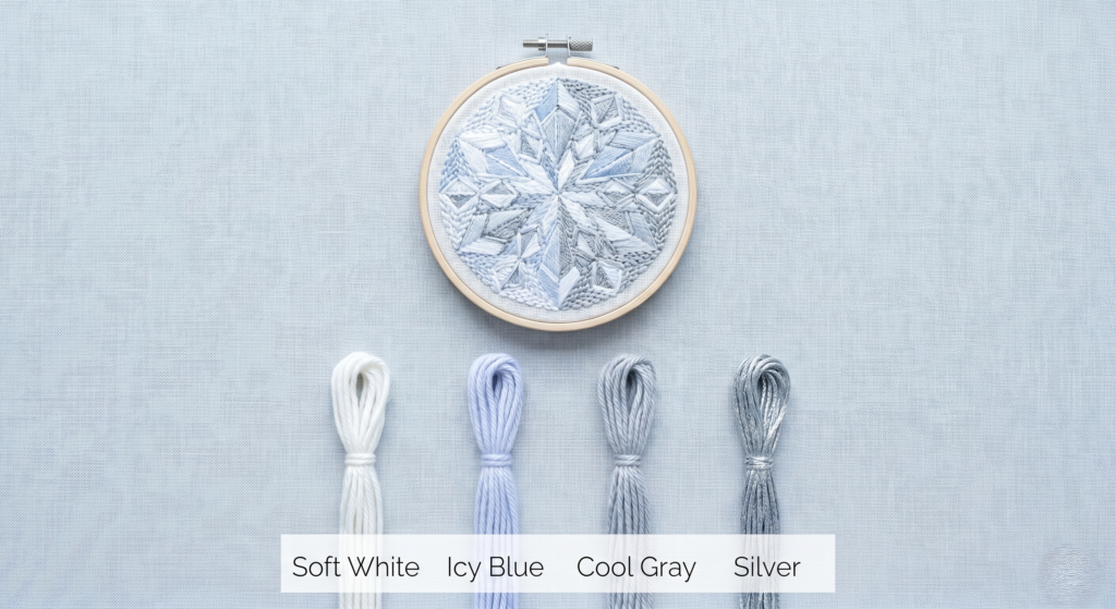 Punch needle pattern of a geometric winter star in a wooden hoop, showcased with a cool blue, white, and silver yarn color palette.